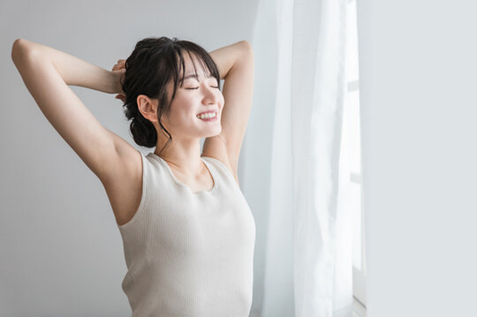 Young woman showing armpit with smooth, clean skin