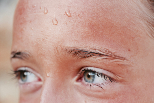A person’s forehead wet with perspiration