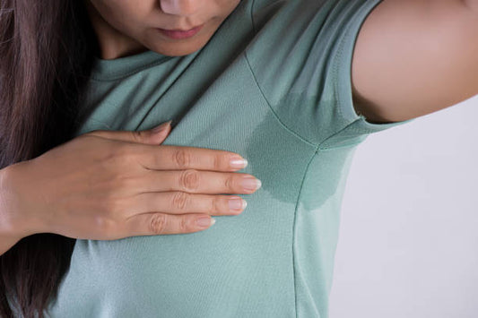A person showing a perspiration stain on their shirt.