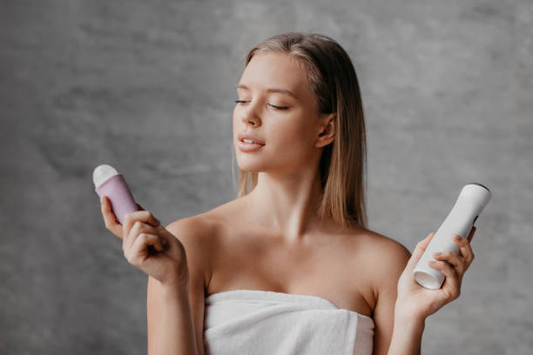 Woman in the bathroom chooses deodorant