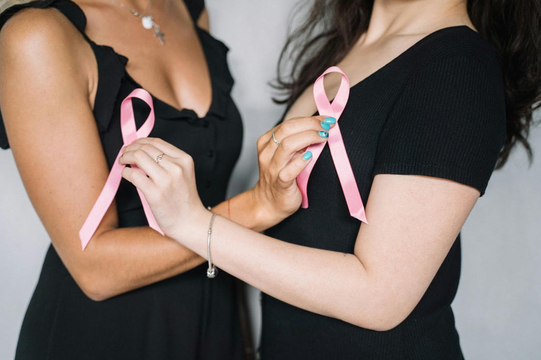 Two women holding breast cancer awareness ribbons.